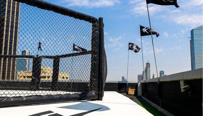 TKMMAFIT Outdoor boxing ring and vibrant city surroundings.
