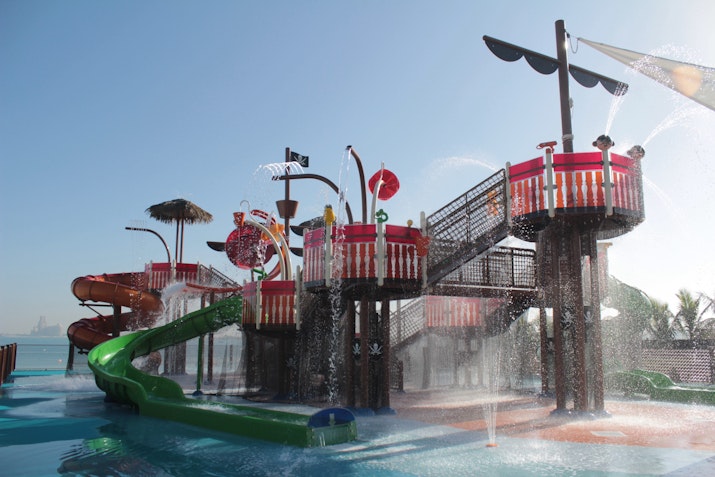 Colorful water playground with slides and water fountains for children.