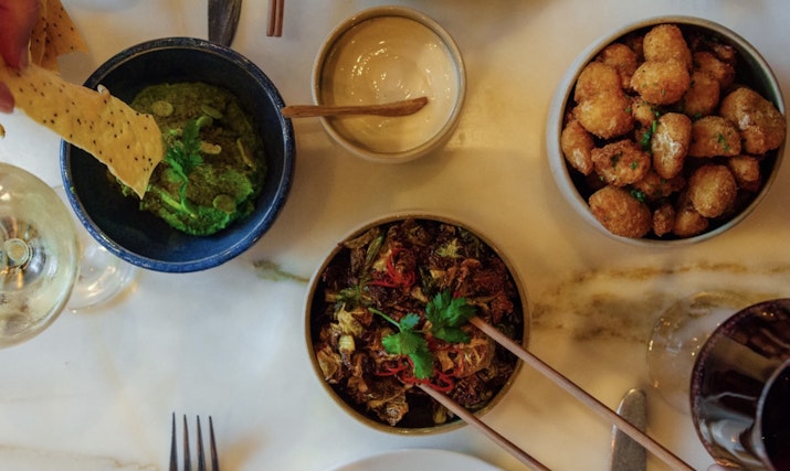 Assorted gourmet dishes served on a marble table.