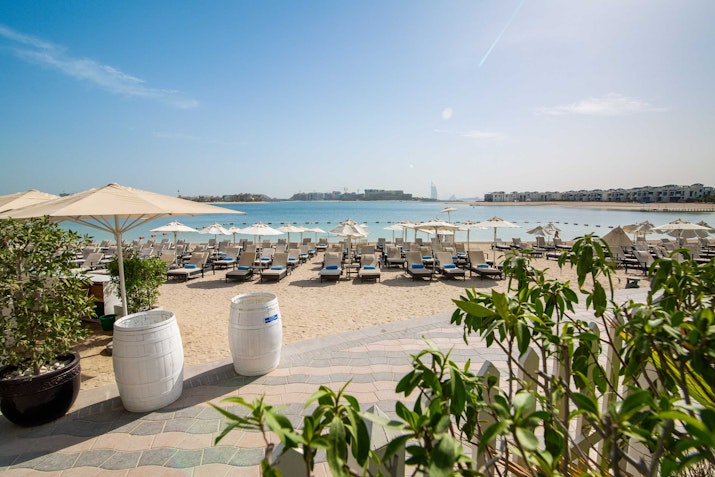 Resort beach with sun loungers and umbrellas overlooking the sea