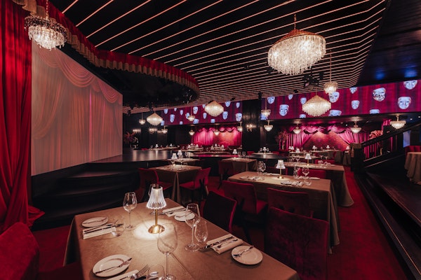 Sophisticated dining area with dim lighting, ornate chandeliers, and plush seating, creating an intimate and luxurious atmosphere.