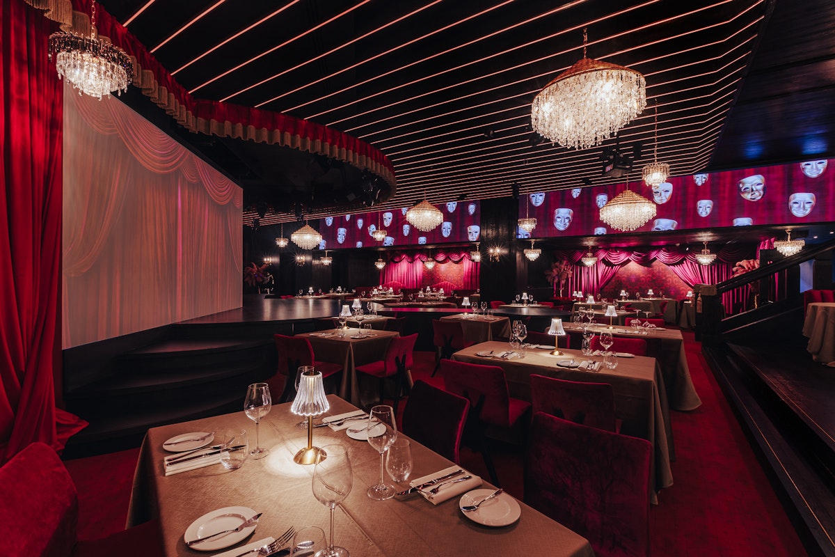 Sophisticated dining area with dim lighting, ornate chandeliers, and plush seating, creating an intimate and luxurious atmosphere.