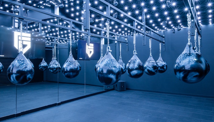 FitGround A high-tech boxing studio featuring hanging punching bags under a ceiling of LED lights, creating an intense and focused environment for boxing and fitness training.
