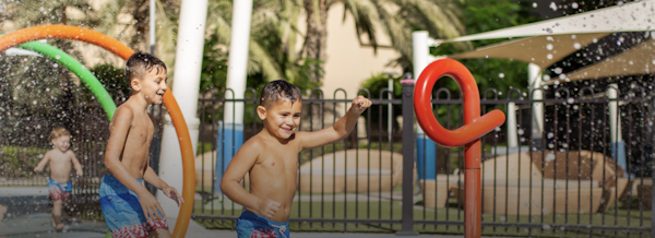 Children enjoying a splash pad with colorful water features.