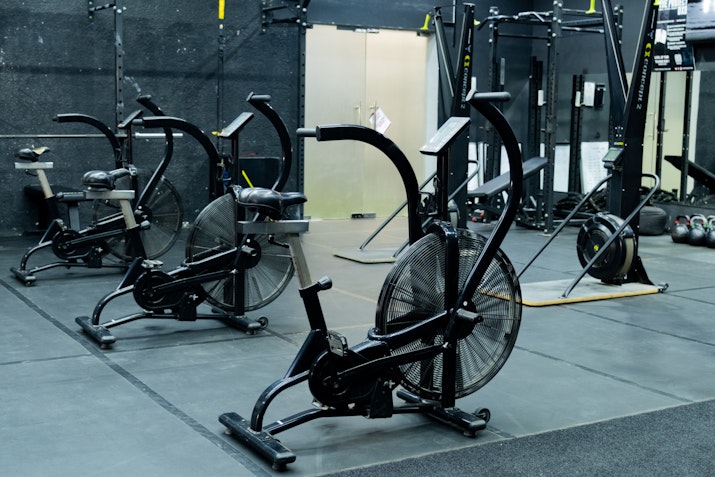Gym setup featuring multiple air bikes on a black floor, perfect for high-intensity interval training and endurance workouts