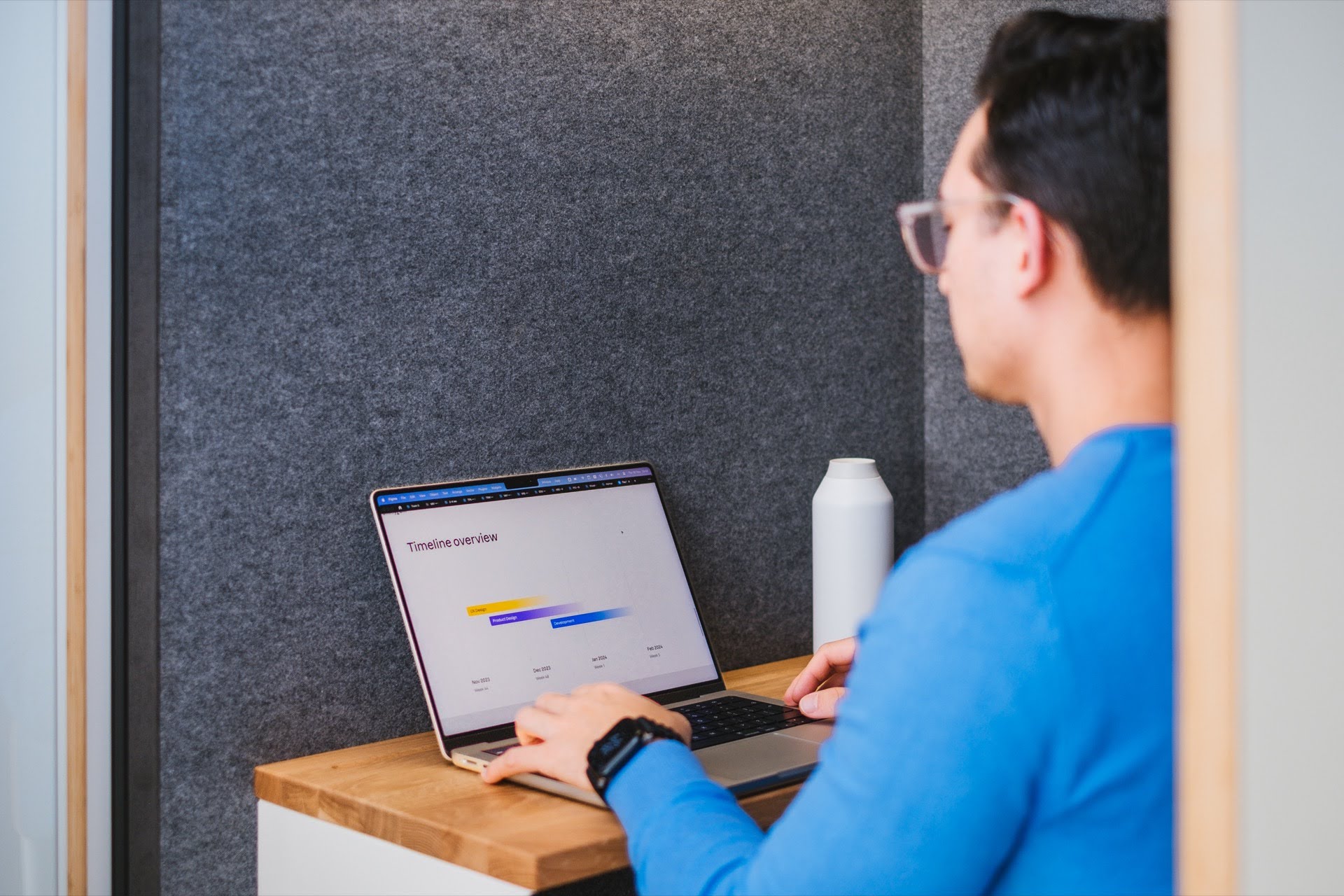 Man sitting behind a desk looking at laptop