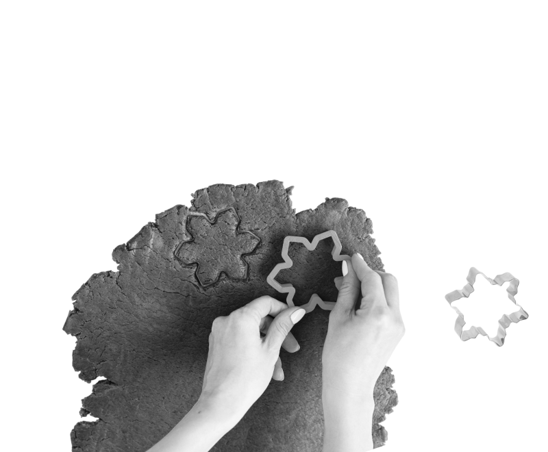 Hand using cookie cutters on dough