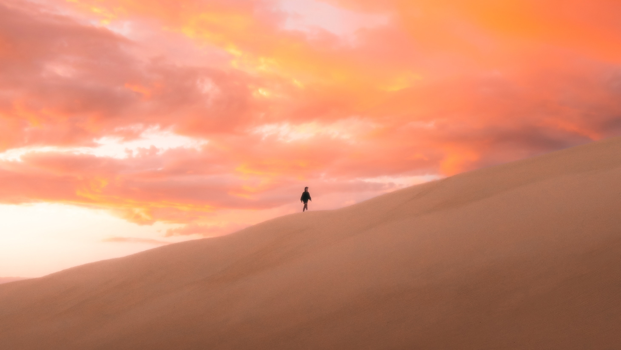 man walking on a sand dune