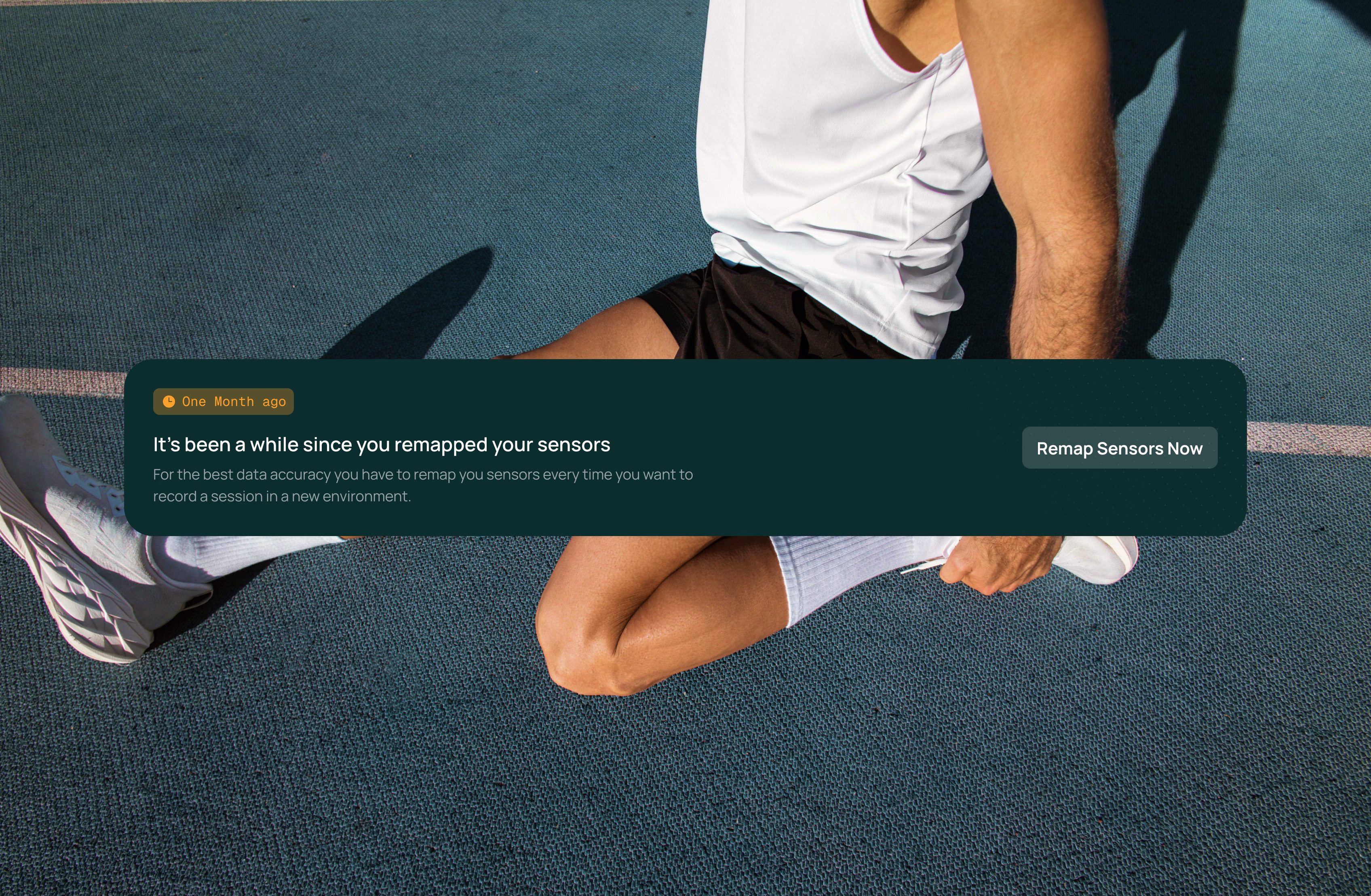 A person in athletic wear sits on a sports court, stretching one leg. An on-screen notification says, "It's been a while since you remapped your sensors," with a button labeled "Remap Sensors Now.