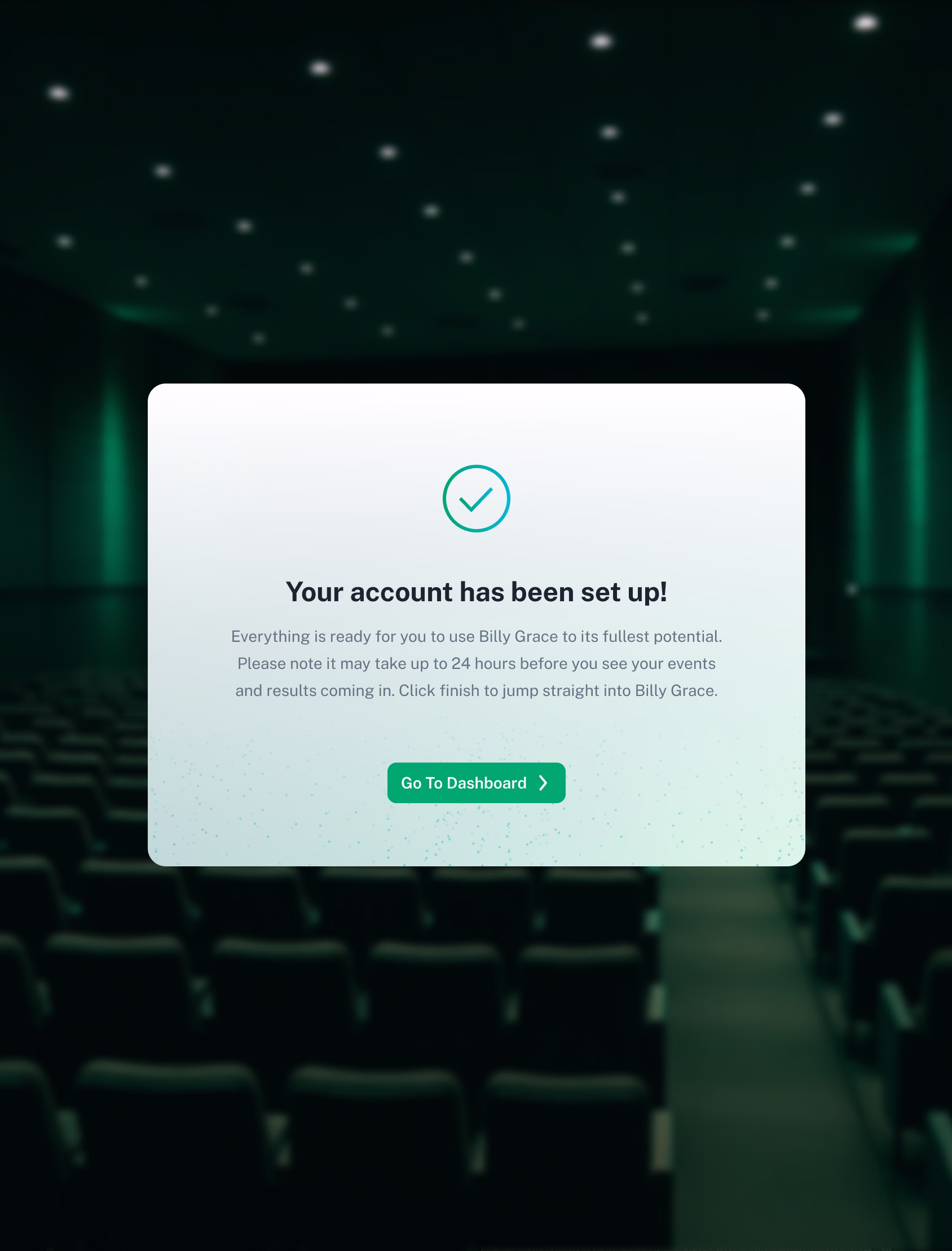 A confirmation screen displays "Your account has been set up!" with instructions and a green "Go To Dashboard" button, over a blurred background of an empty, dark theater with rows of seats.