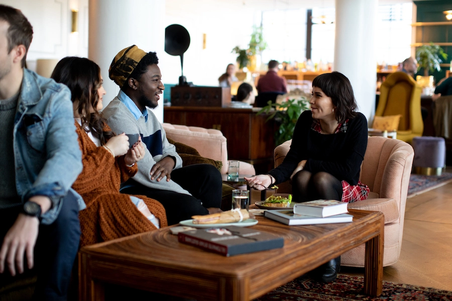 people chatting over food and drink in the lobby