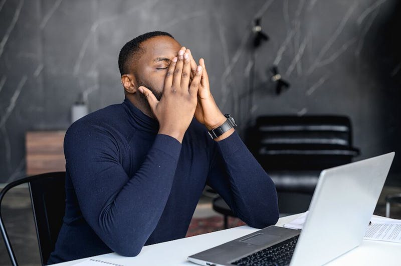 Man with his hands on his face
