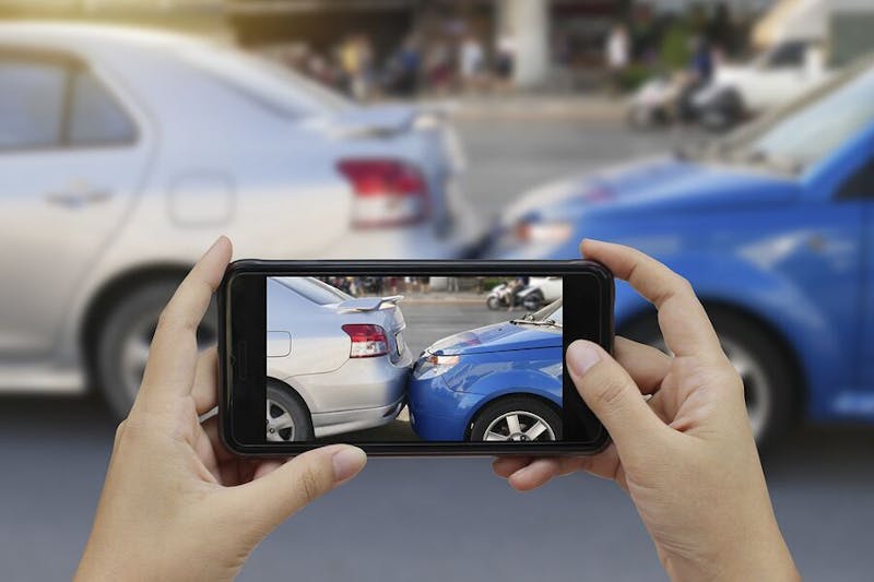 Person taking a photo of a car accident