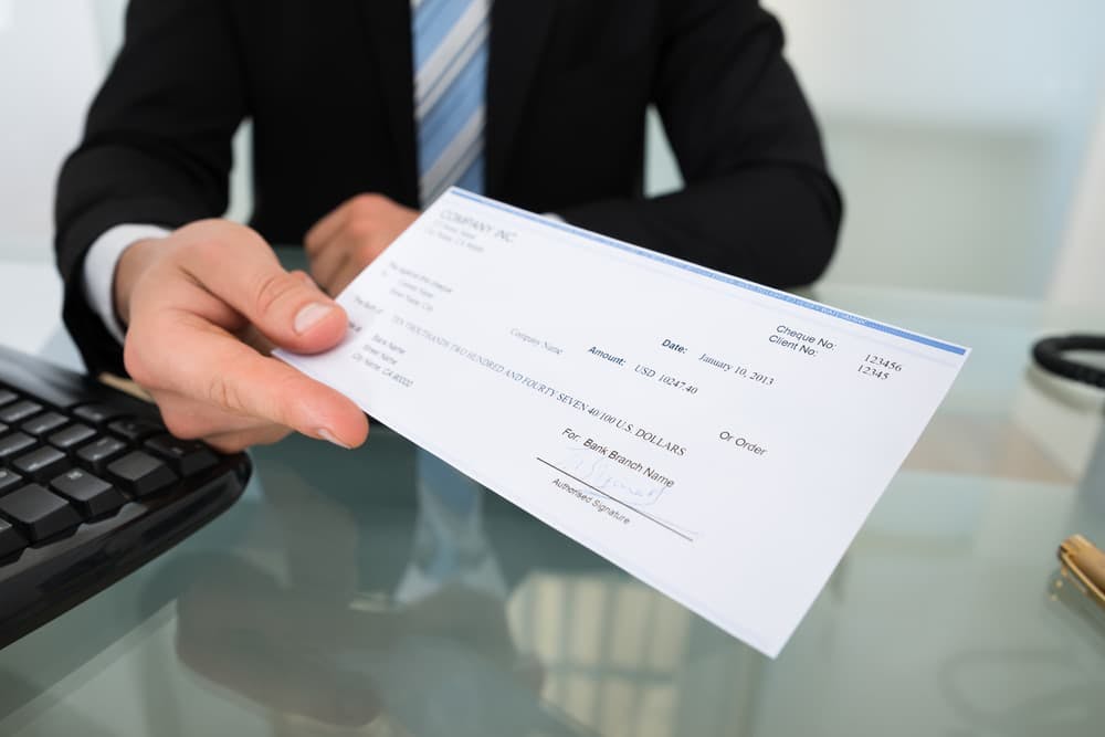 man handing over check
