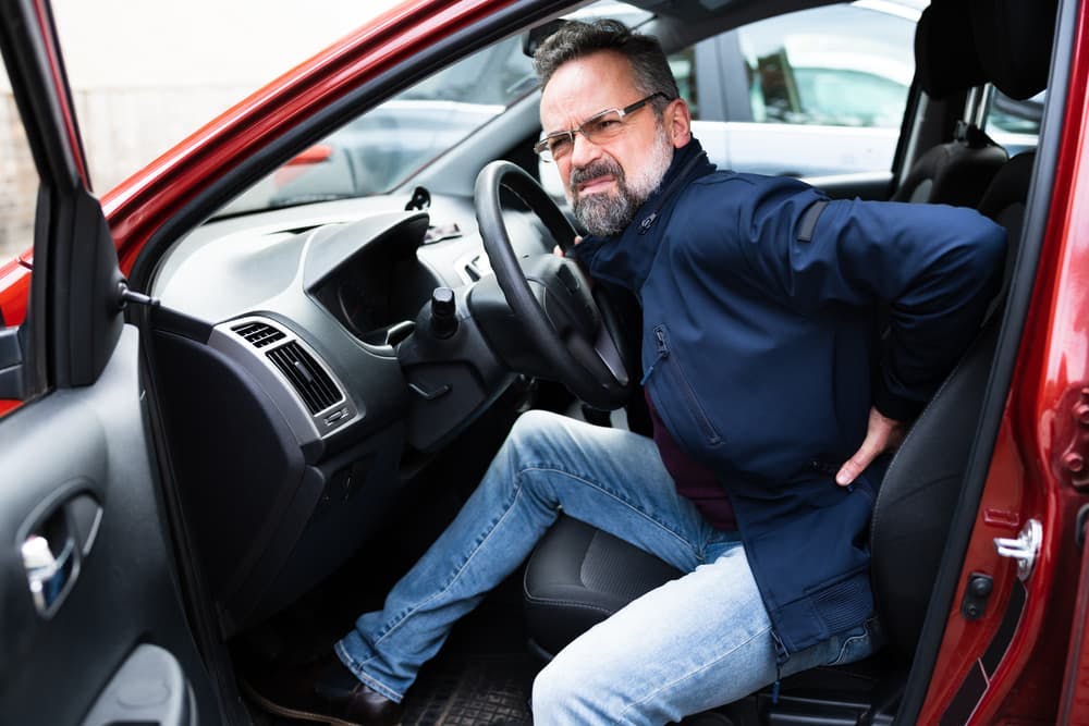 Man holding his lower back in discomfort after a car accident in Houston, Texas