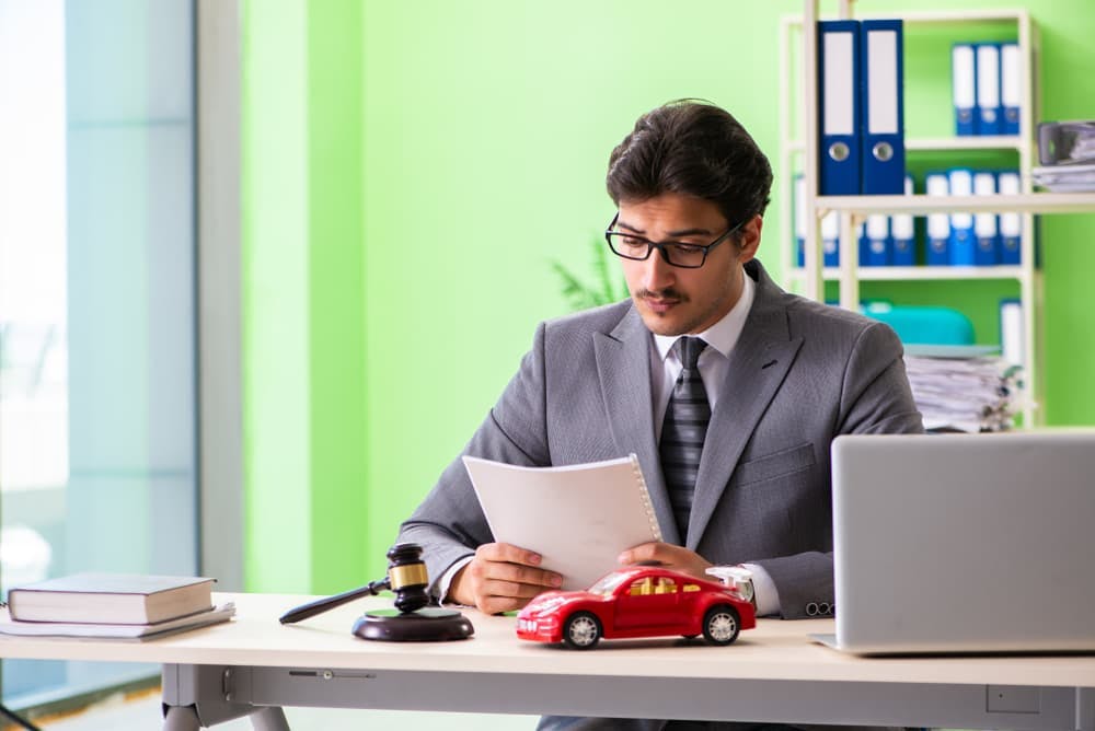 Professional male attorney reviewing documents and working in a law office setting.