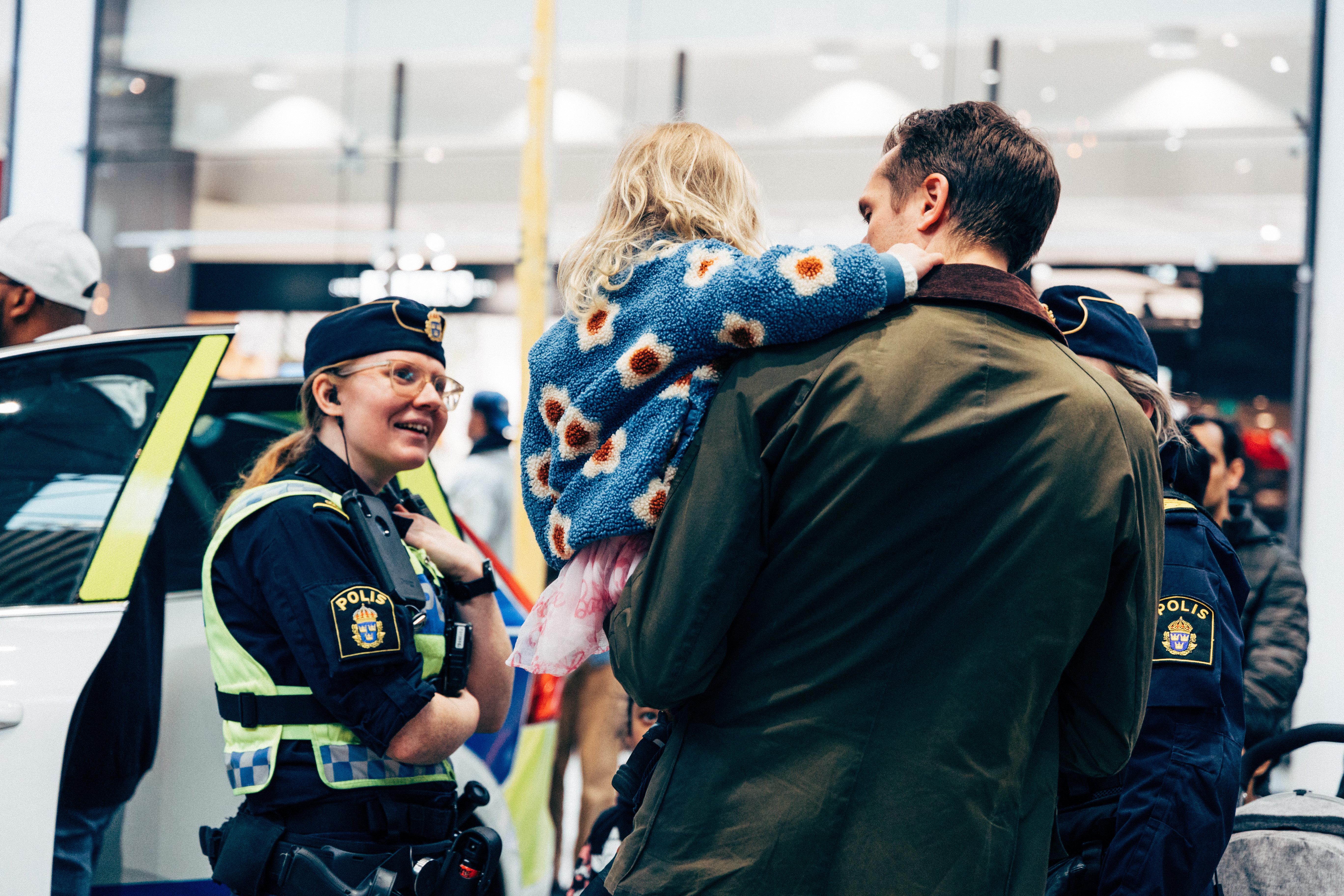 Polis pratar med ett barn och förälder