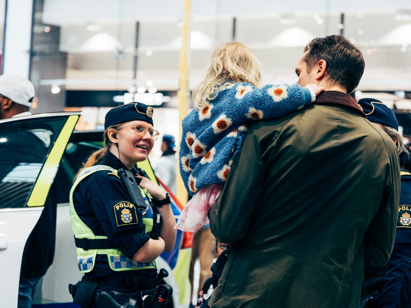 Polis pratar med ett barn och förälder