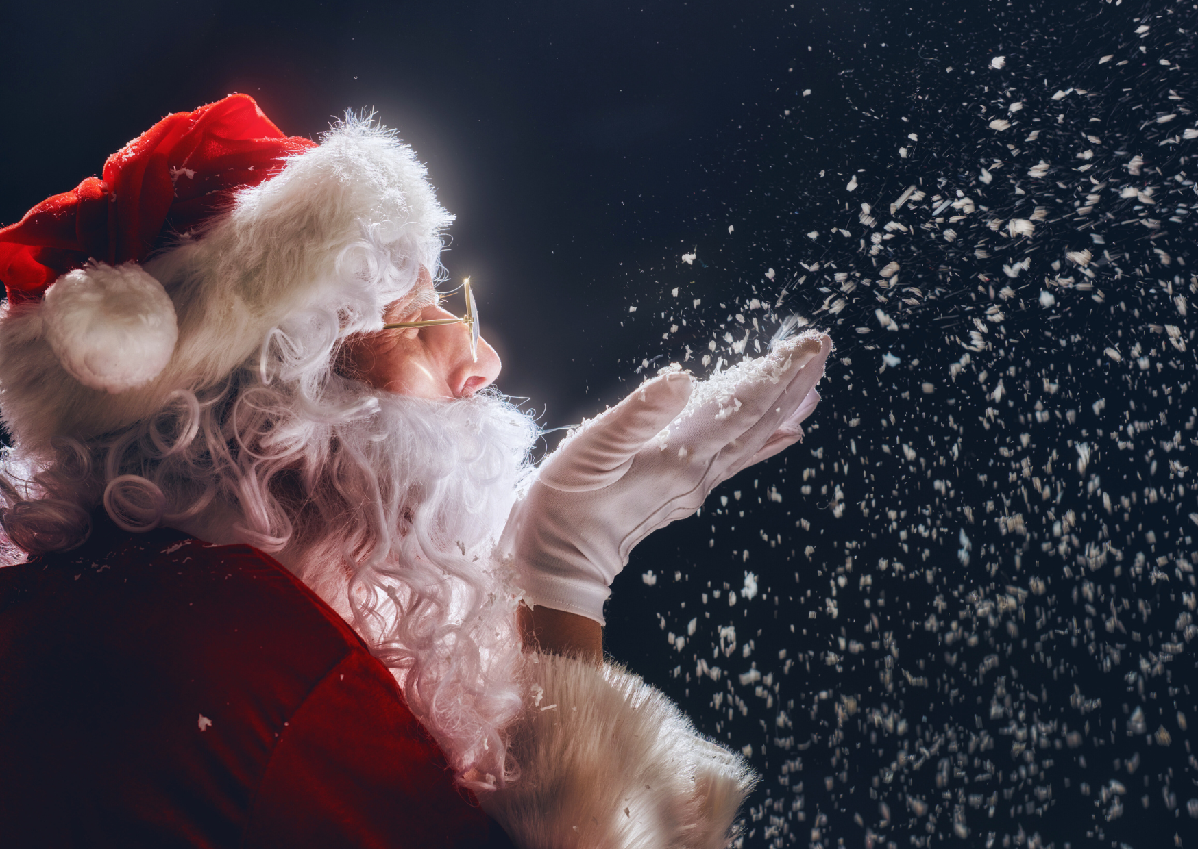 Jultomten blåser snö från sin hand