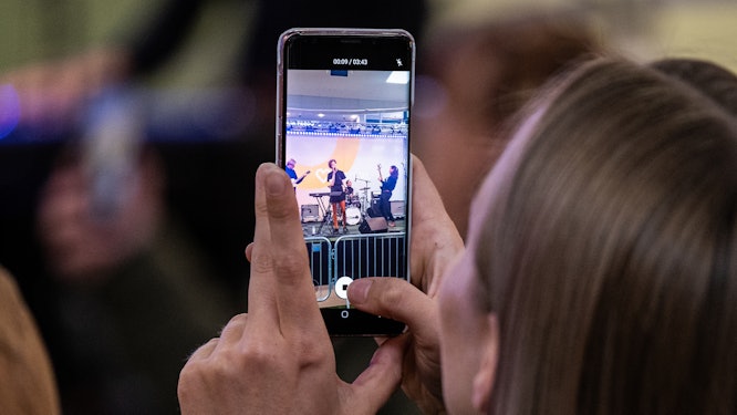Person filmar föreställning med sin telefon