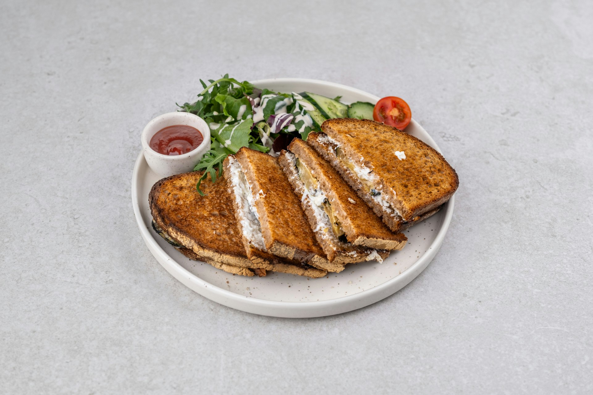 organic sourdough wheat bread with soft goat cheese and grilled zucchini served with tomato ketchup and a small salad, from the oven 1