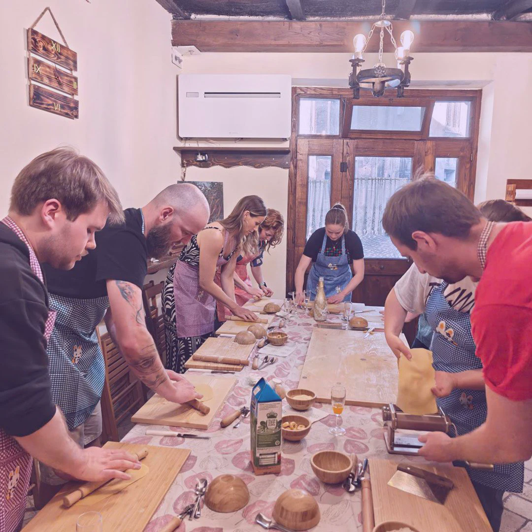 People making pasta around a table