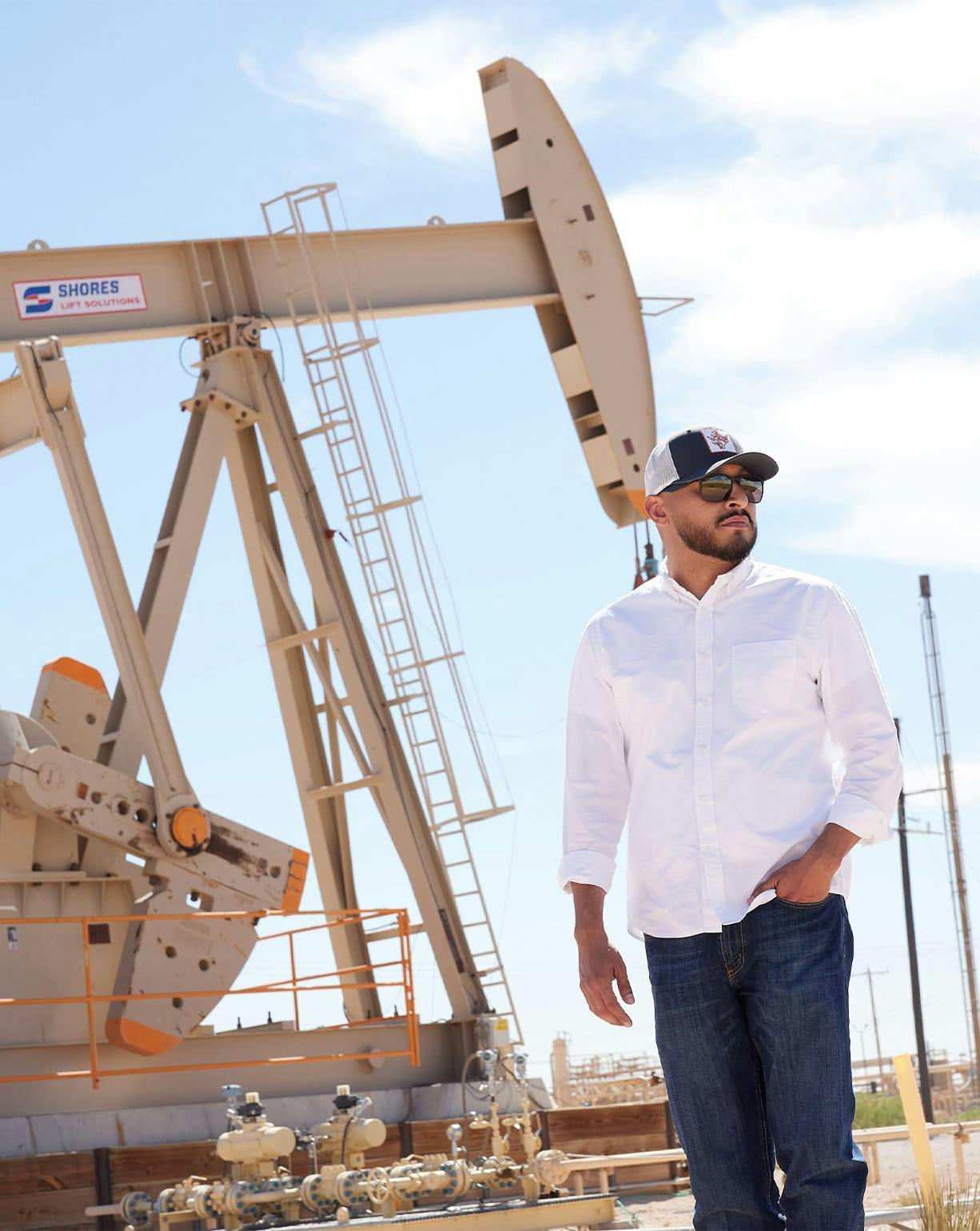man with sunglasses on next to oil machine