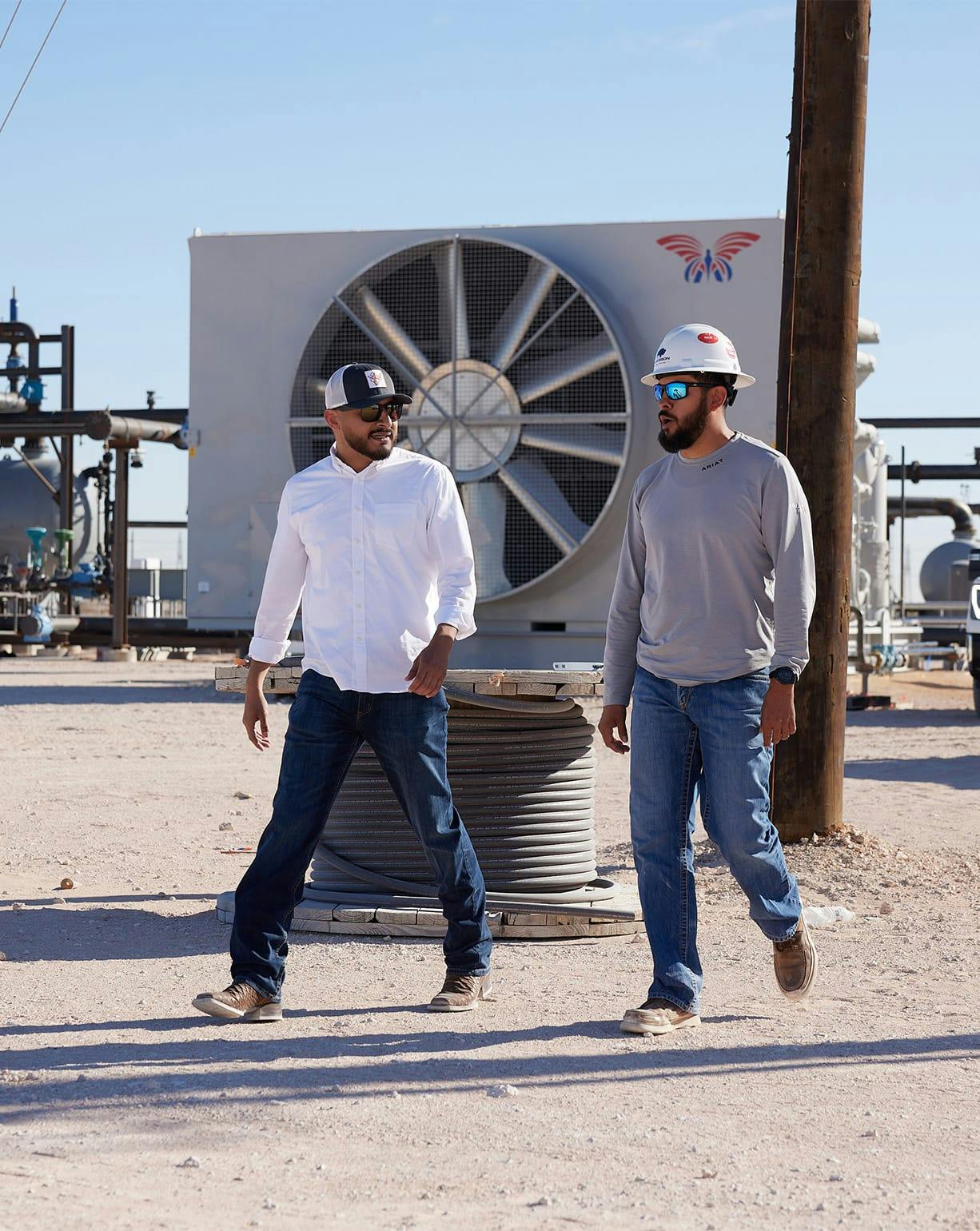 2 men walking and talking on construction site