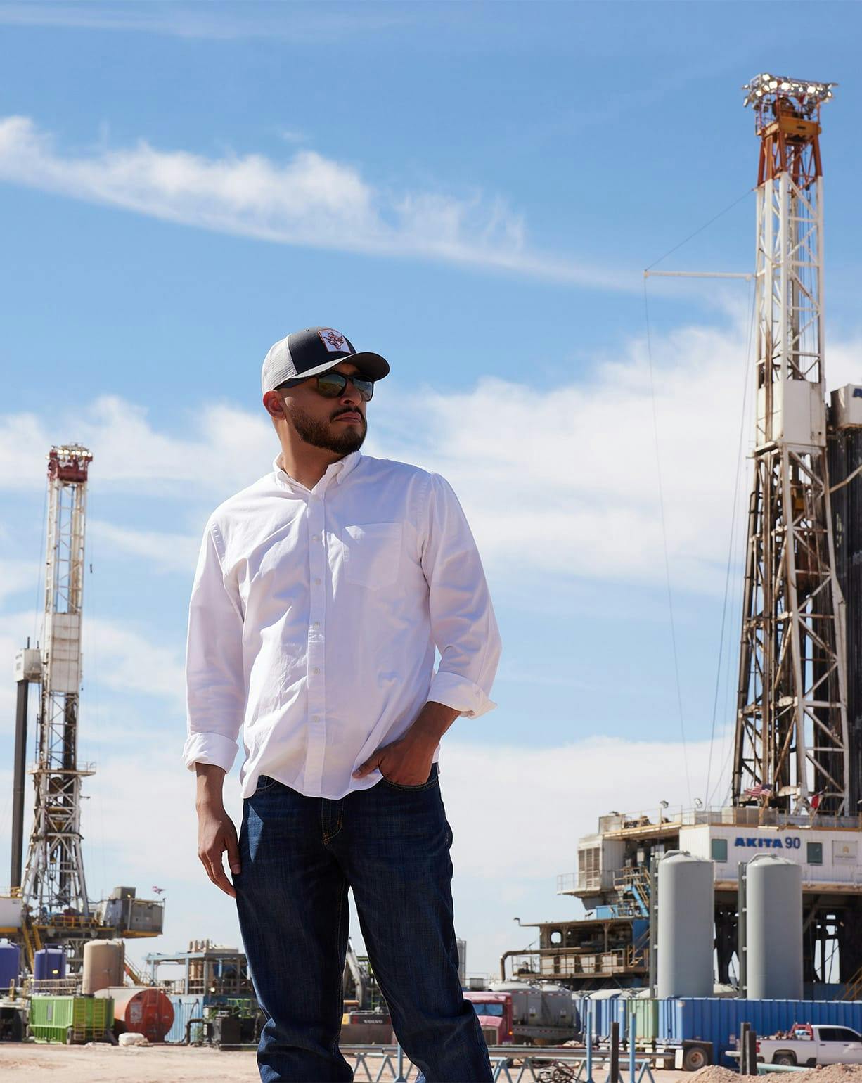 man with hand in front pocket of pants in oilfield