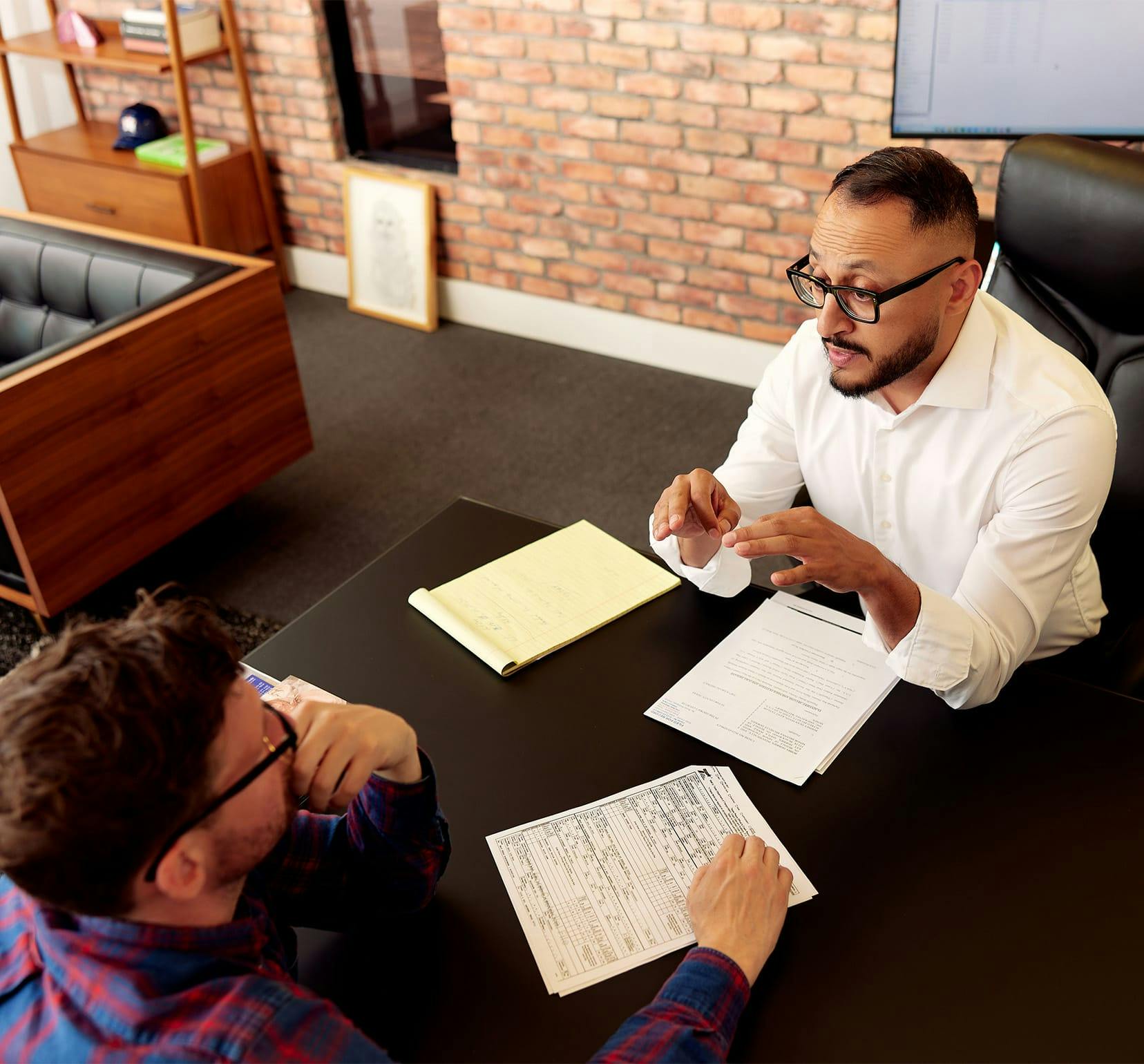 attorney with client and paper work in front of both