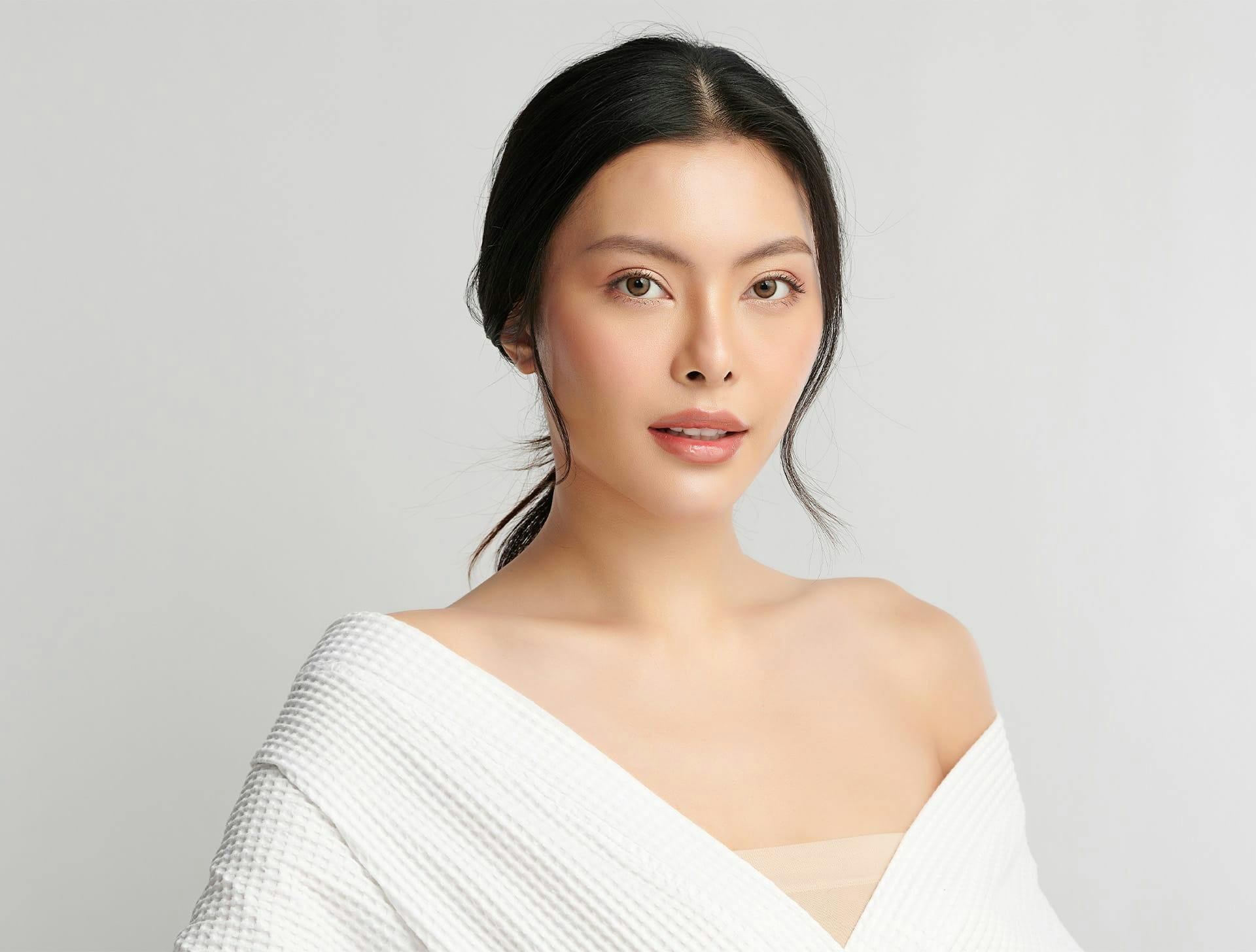 woman in white dress with low ponytail