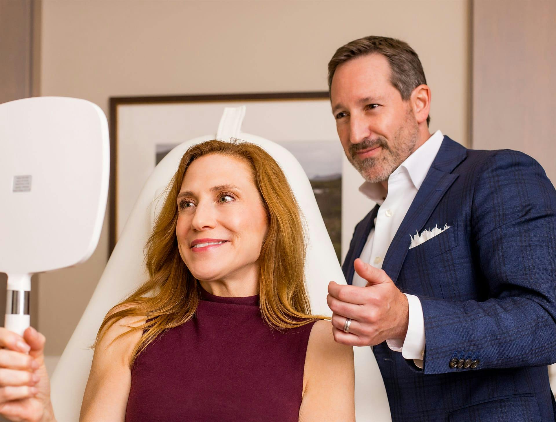 Dr. Morgenstern and client both looking into handheld mirror