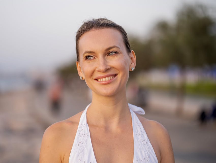 woman in white shirt on beach smiling