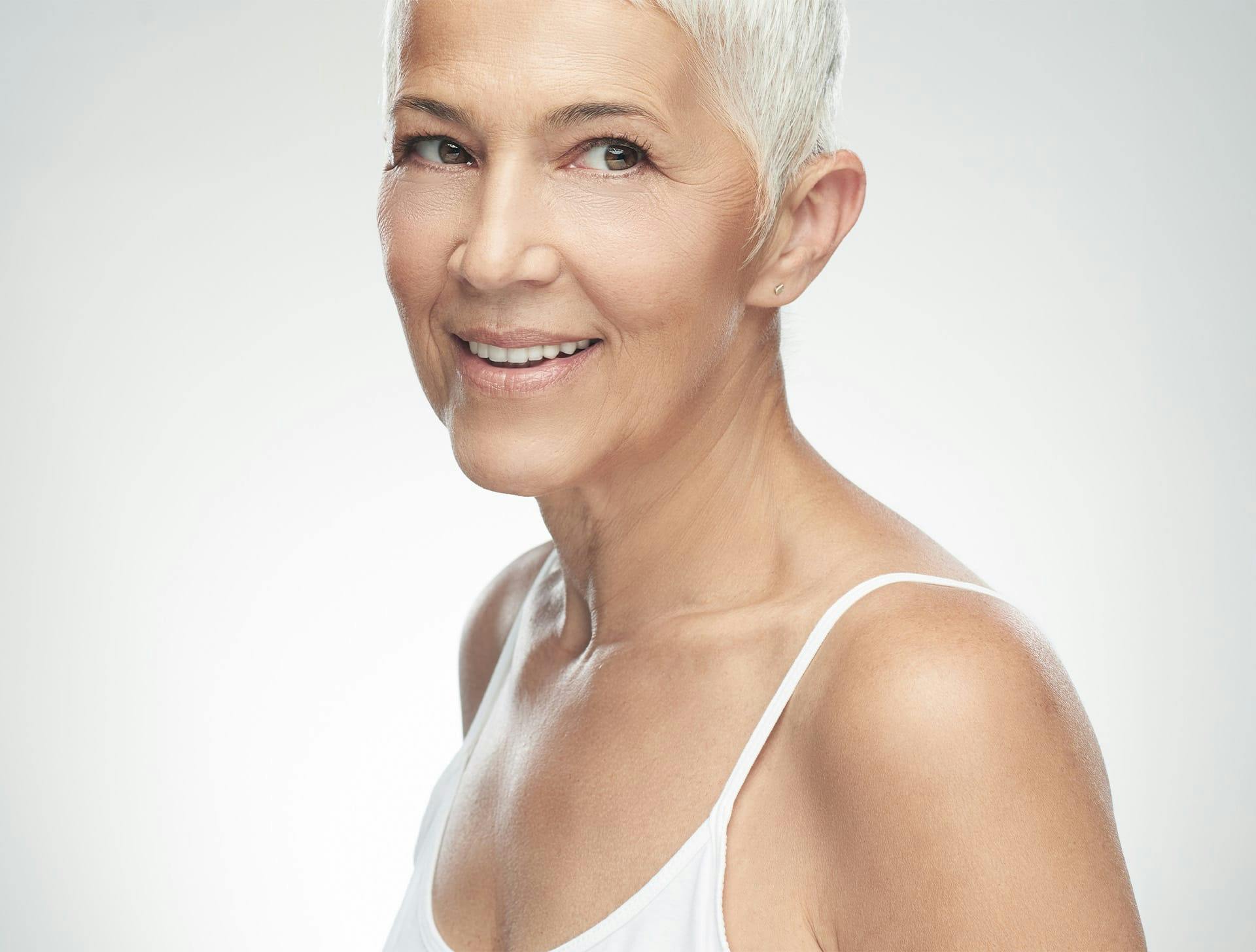 older woman in white tanktop and short hair
