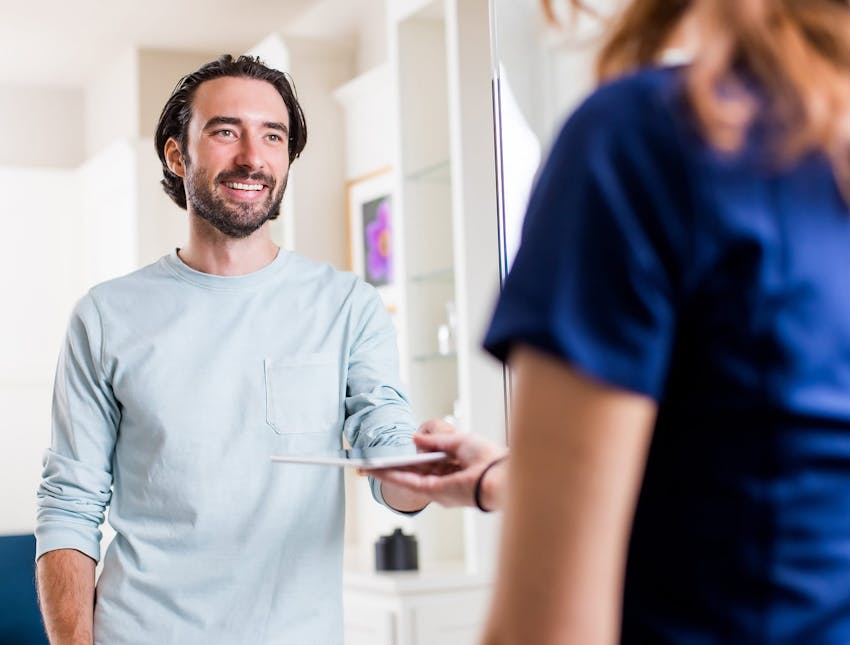 man being given an ipad by a nurse