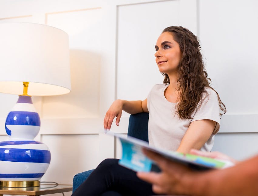 woman sitting in waiting room in white shirt
