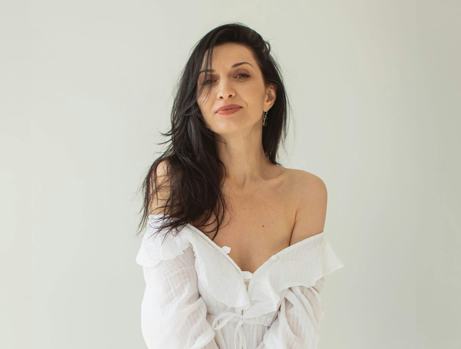 woman with white top off the shoulders with black hair