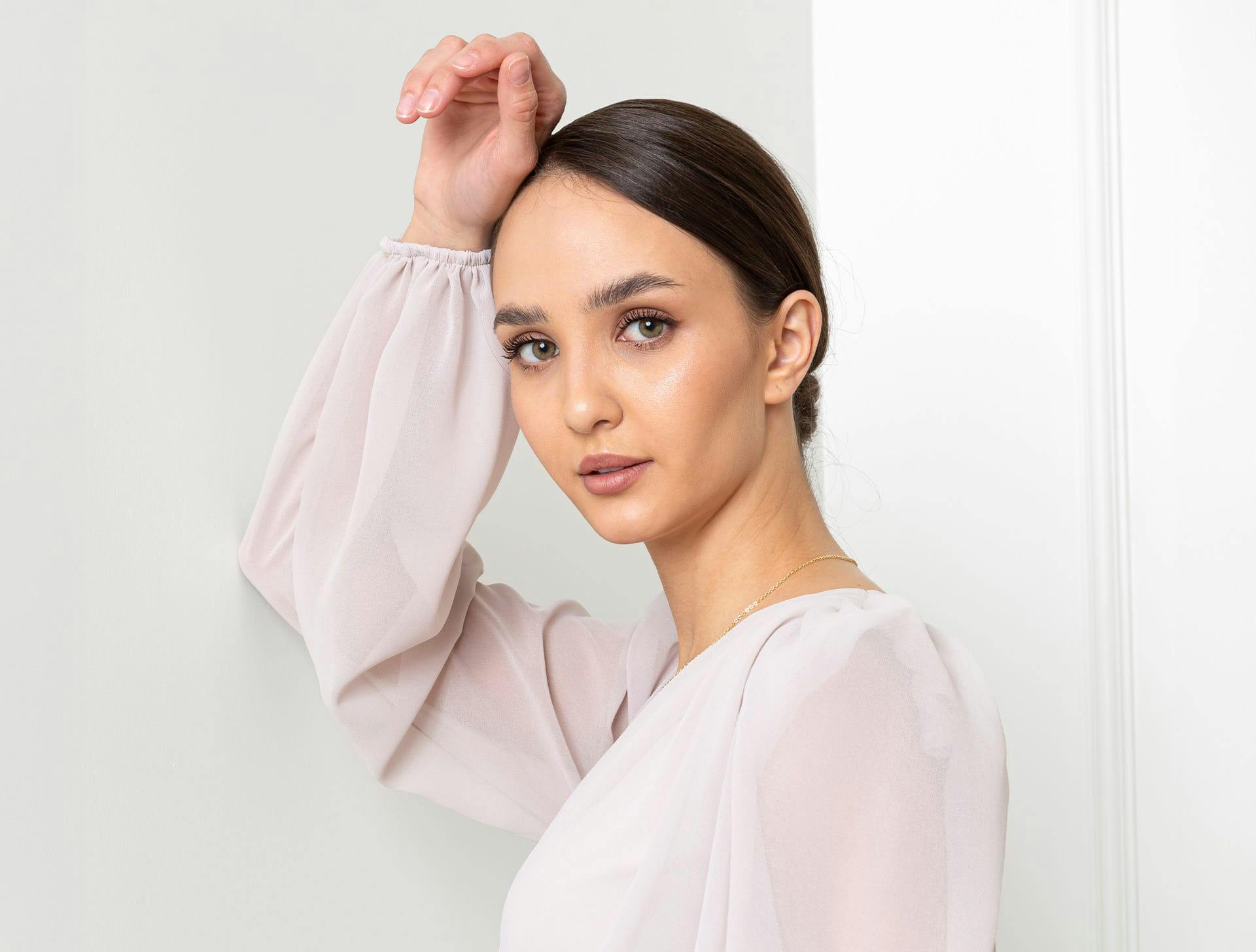 woman in white see-through shirt with slick bun