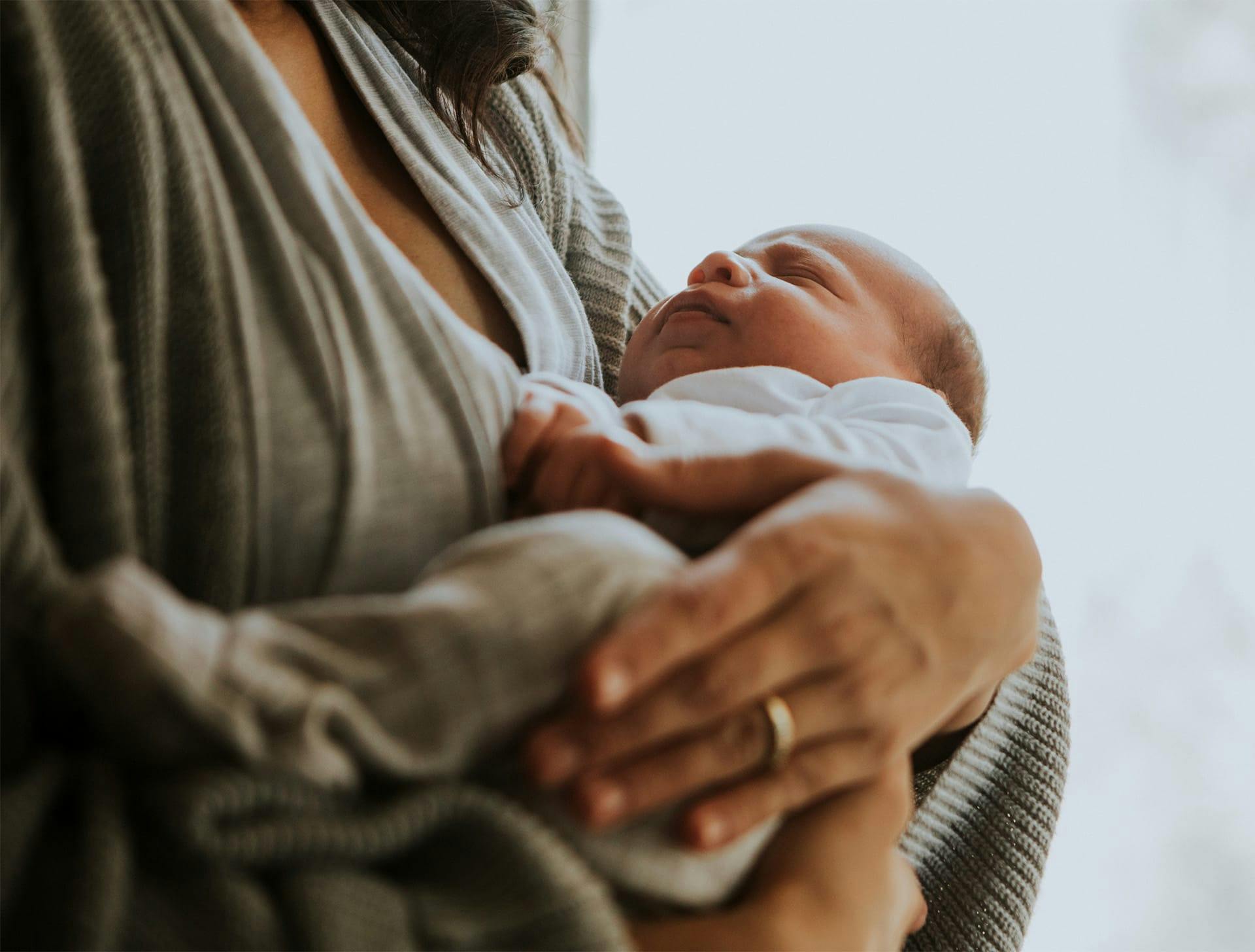 infant in an mother's arms