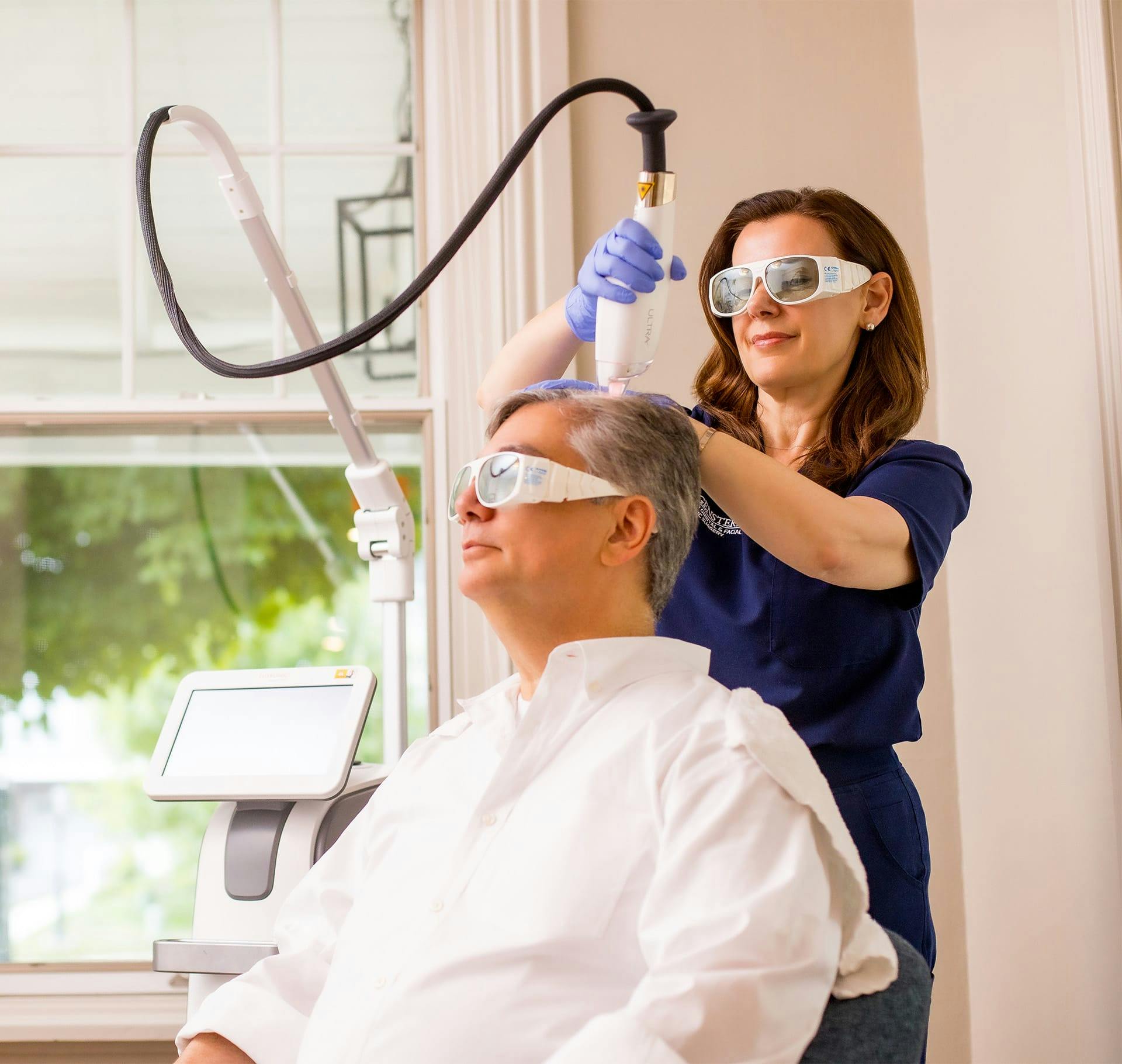 nurse doing hair restoration on older man
