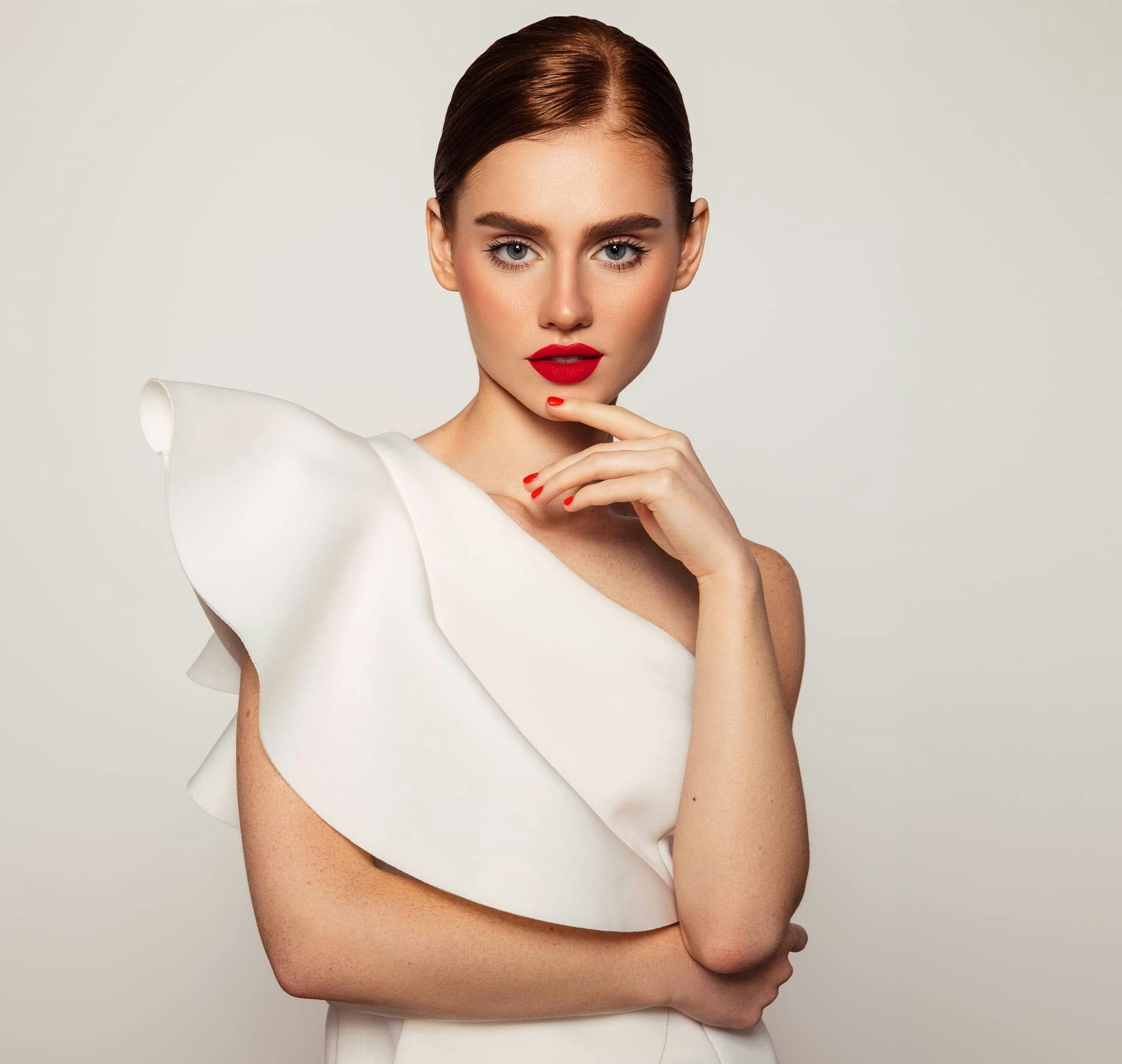 woman in white dress with red lipstick with slick back hair