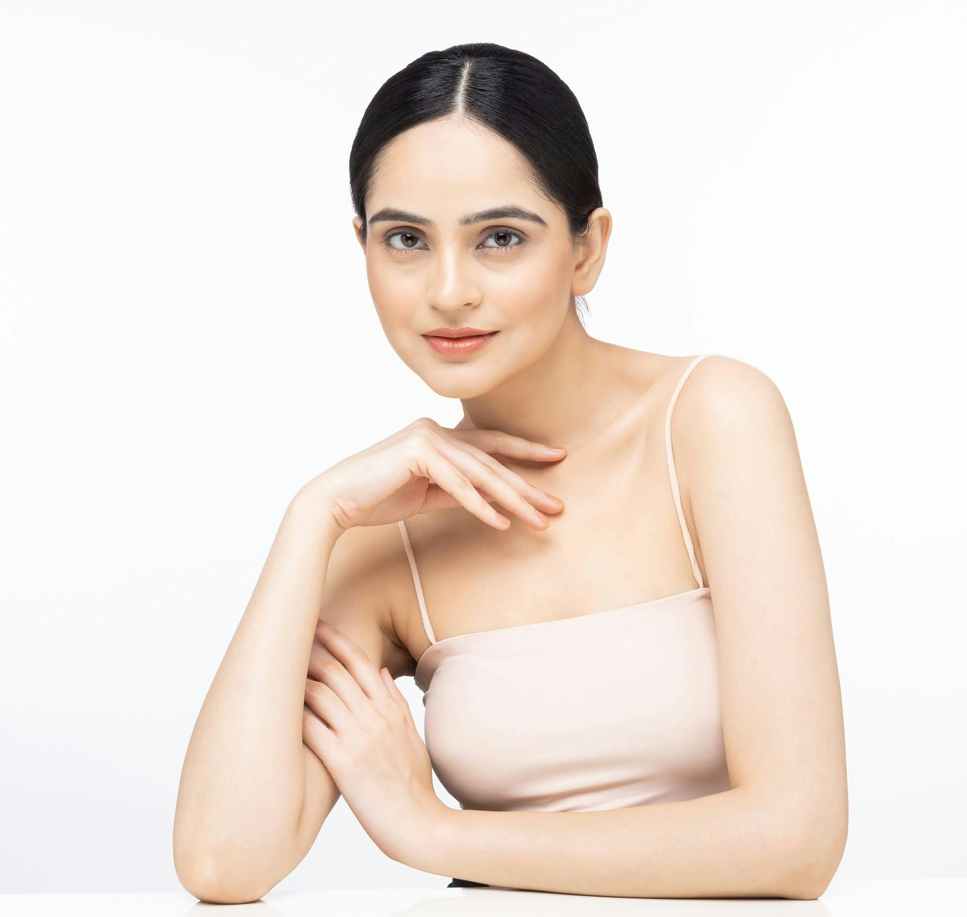 woman with slick back hair in beige top