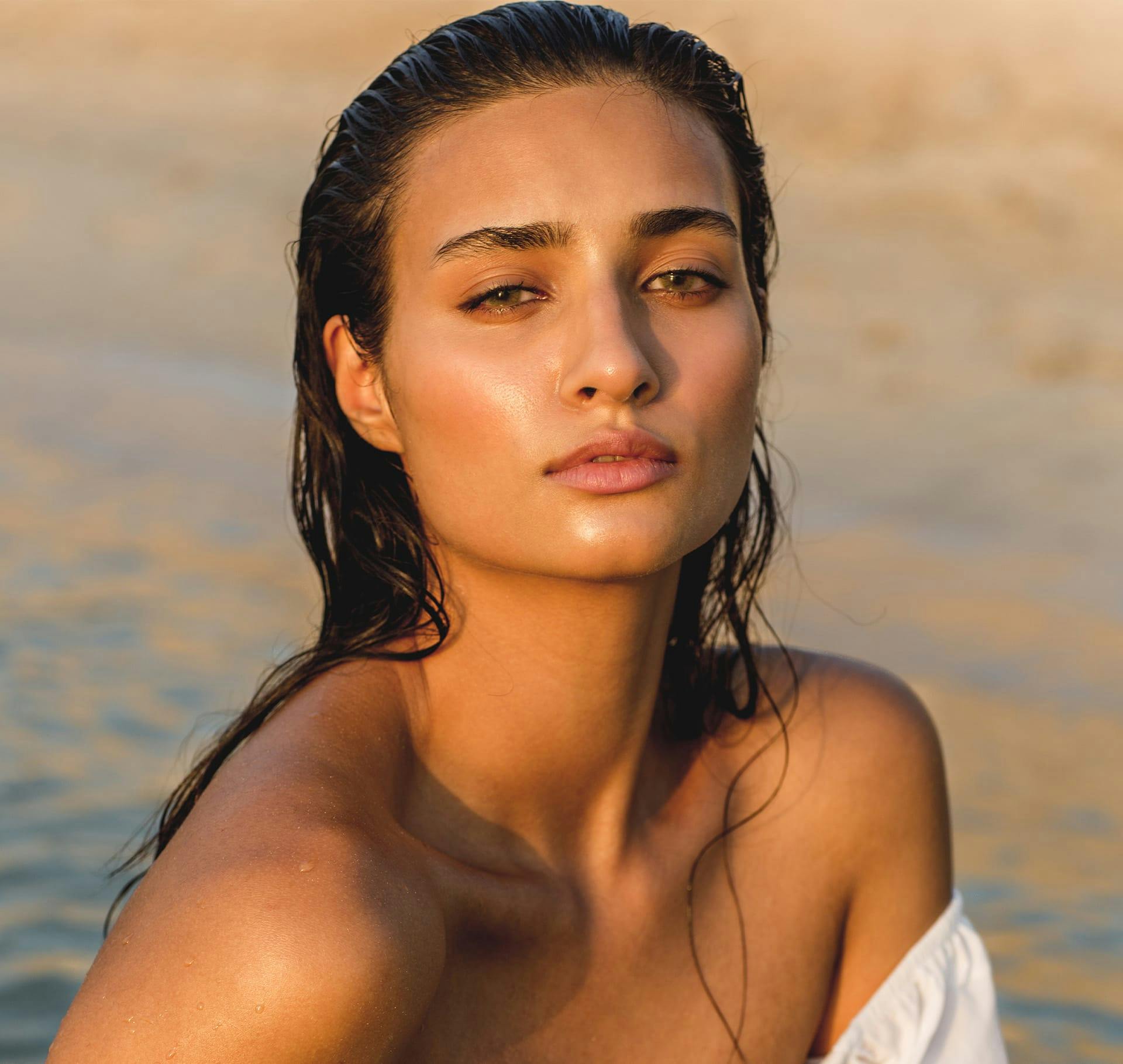 woman with wet hair along the beach shore