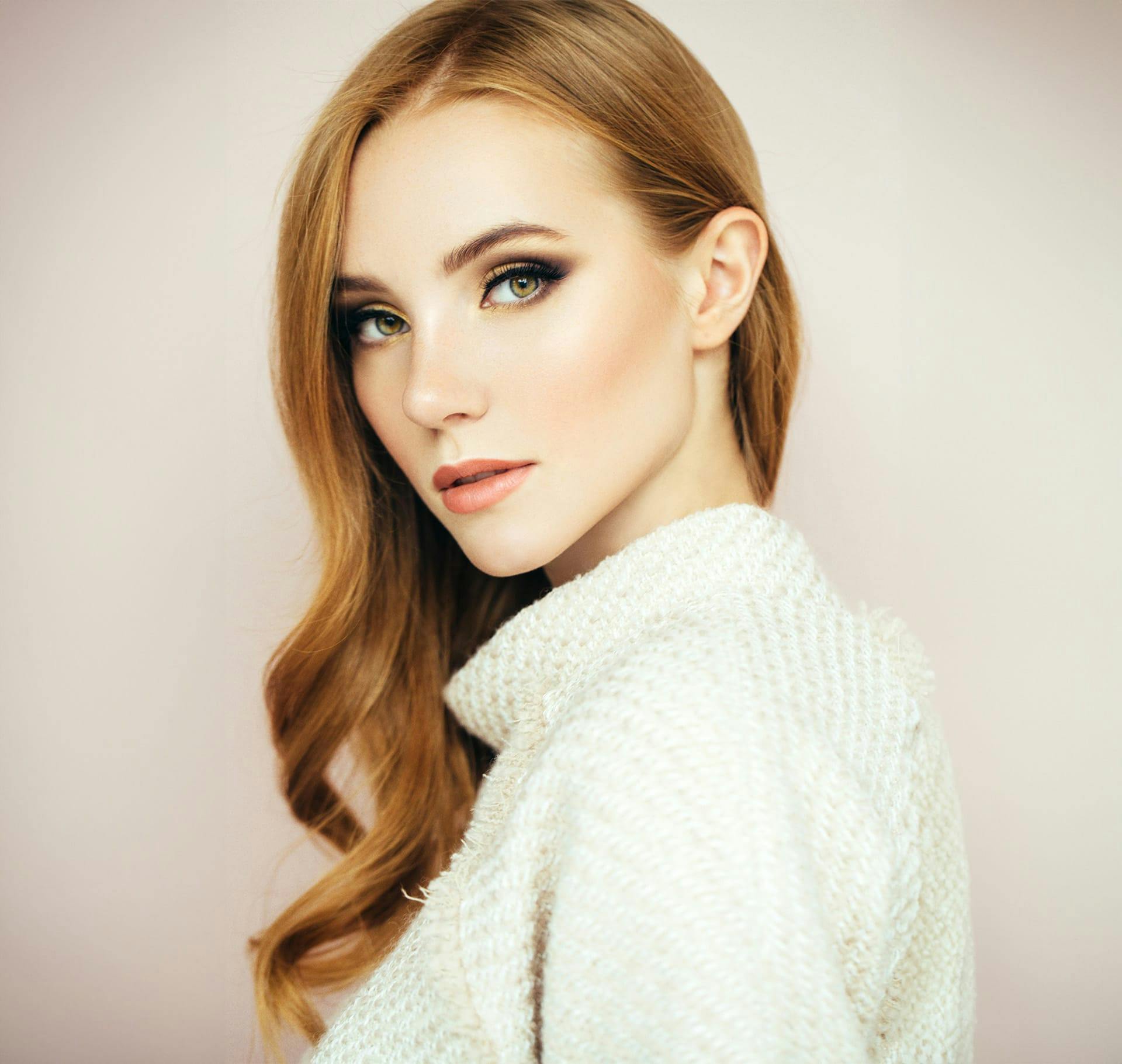 woman with red hair looking over her shoulder