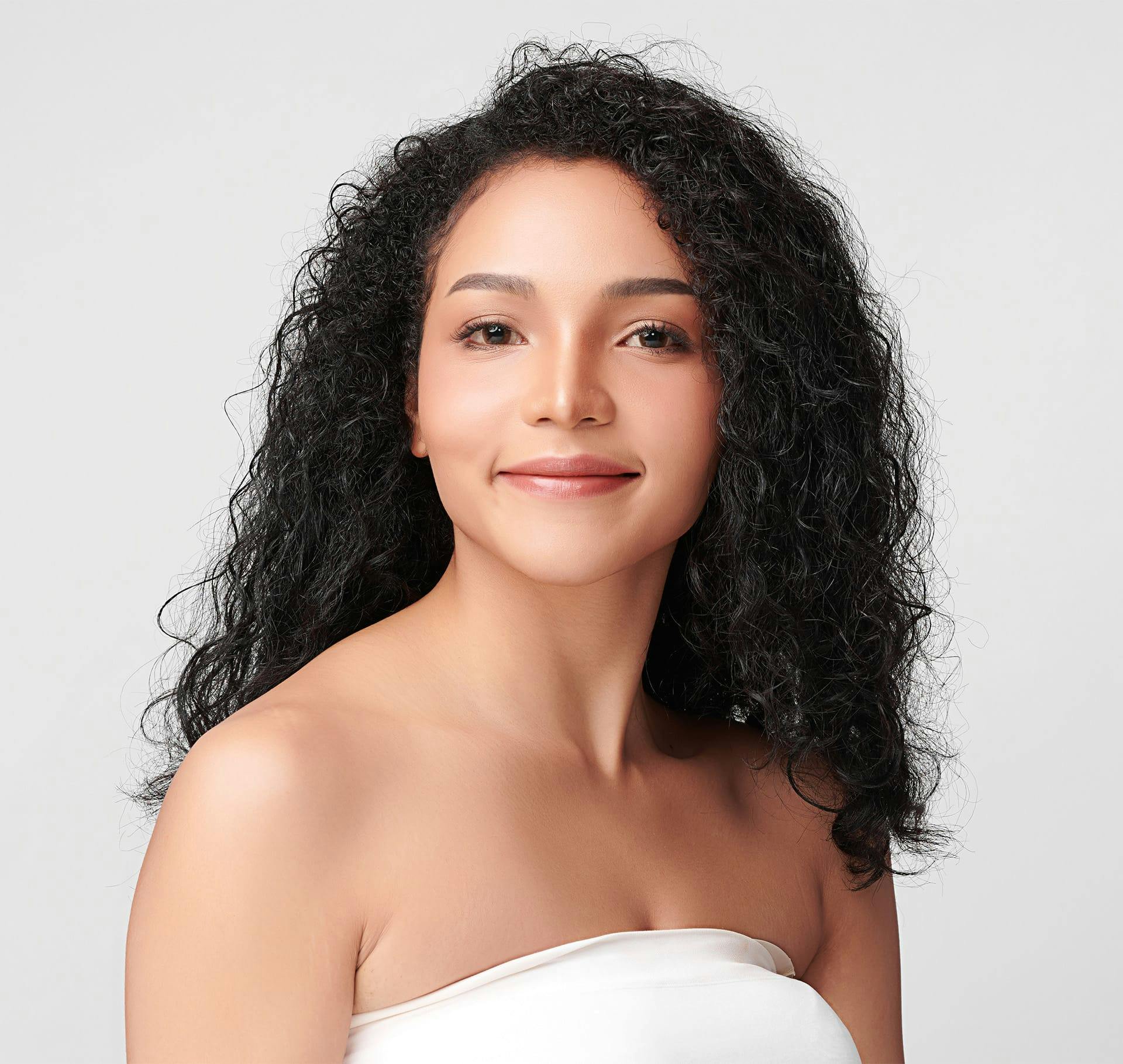 woman with black curly hair smiling forward