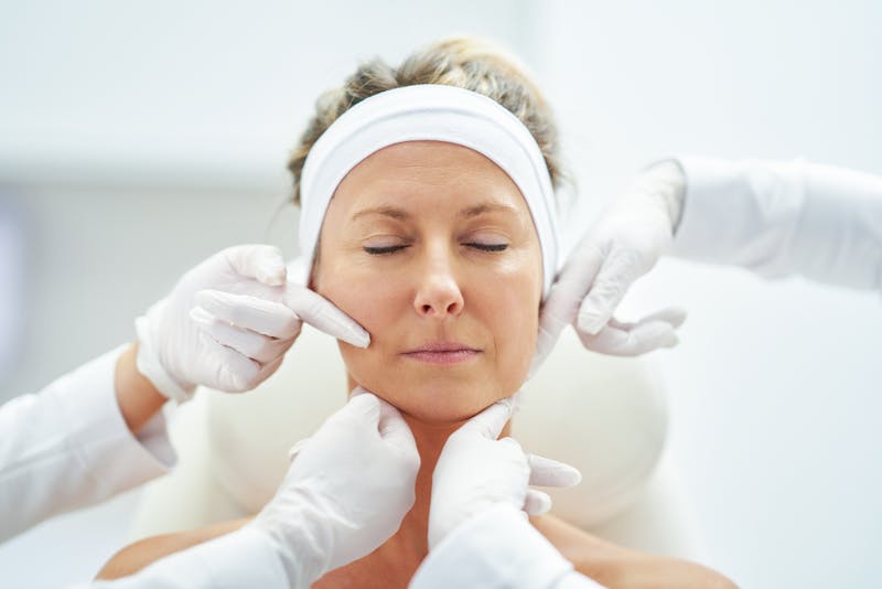 Doctor hands touching womans face