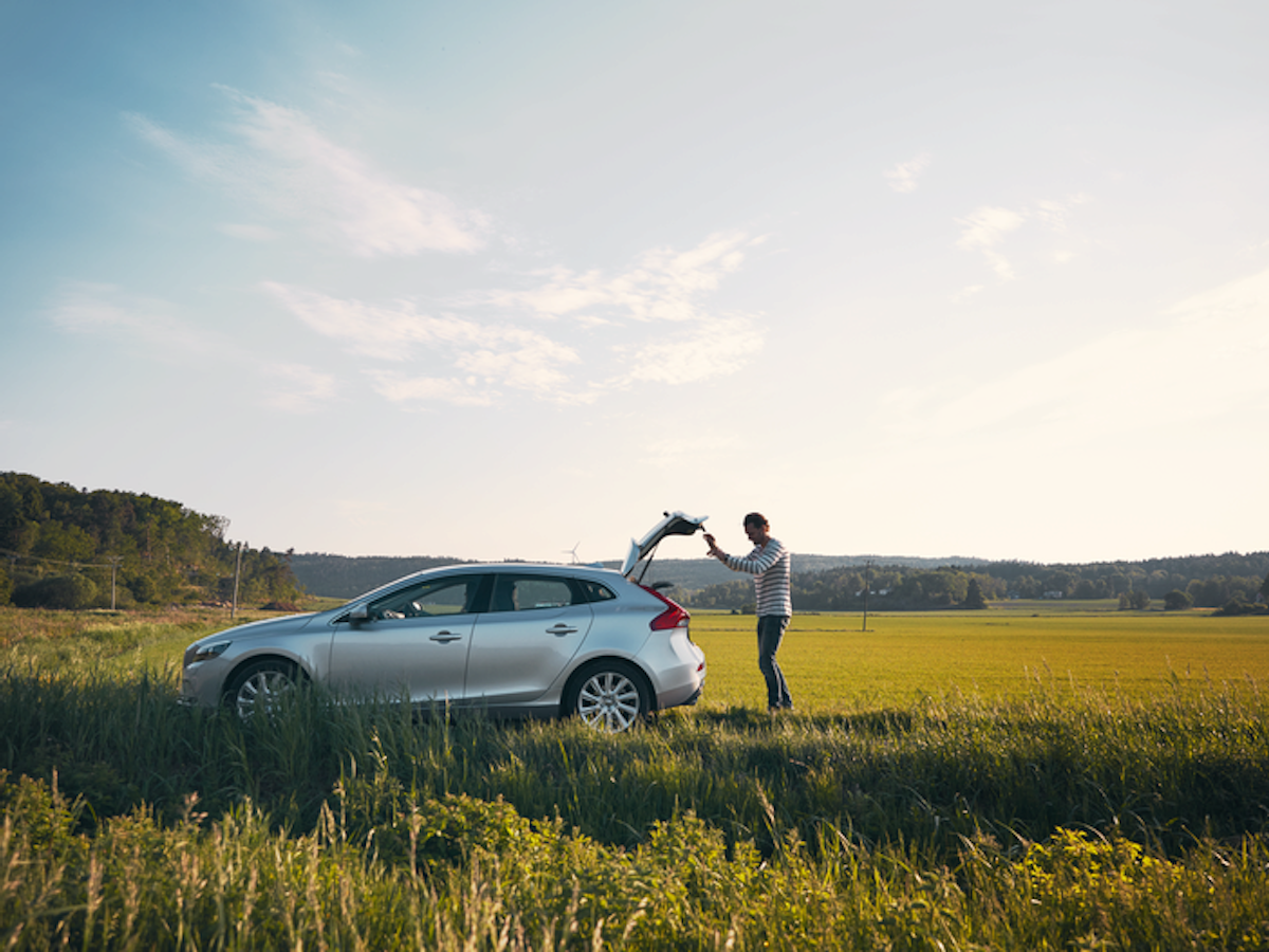 Man vid bil på ett fält