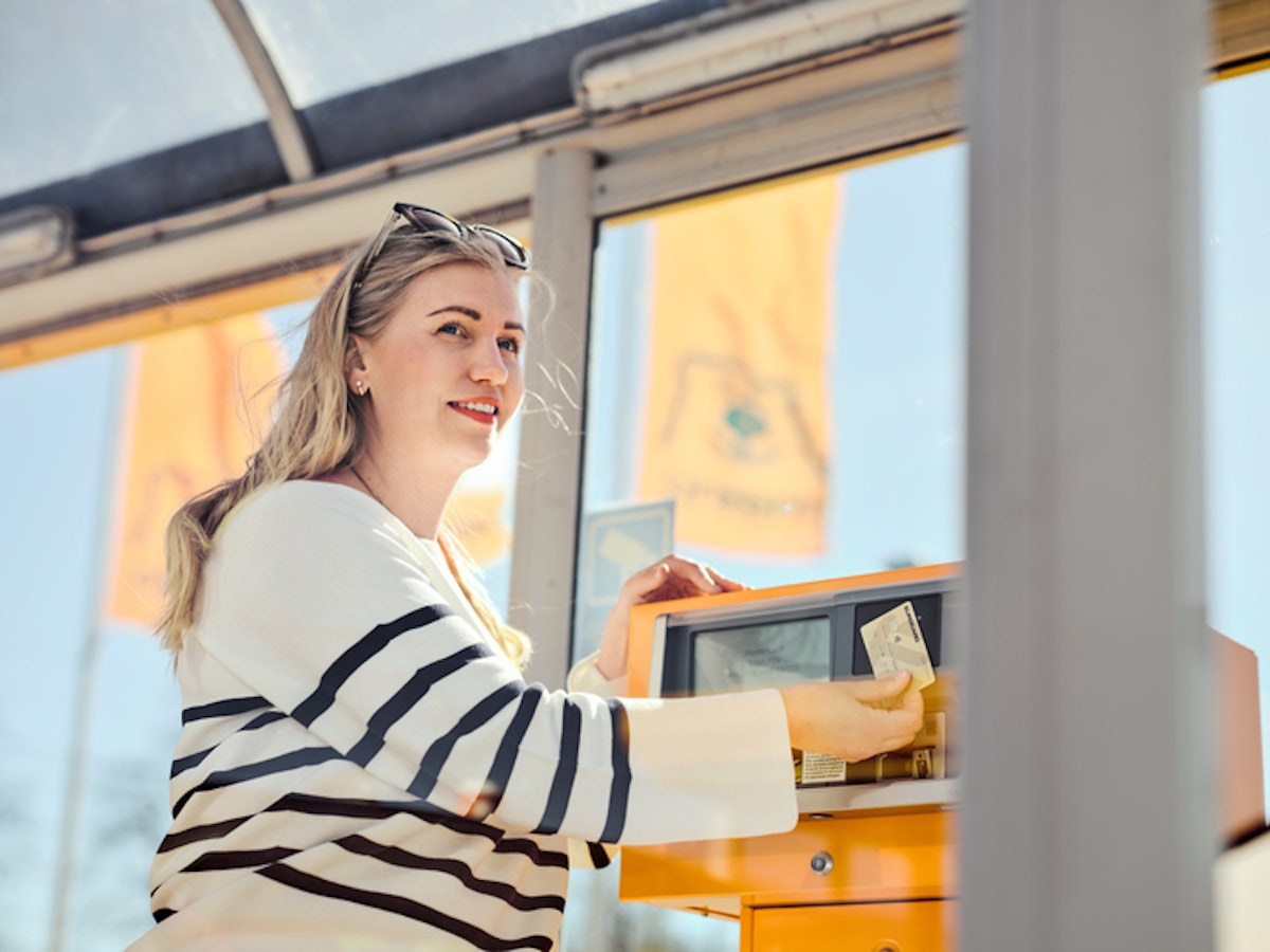 Människa betalar drivmedel vid tank på station.