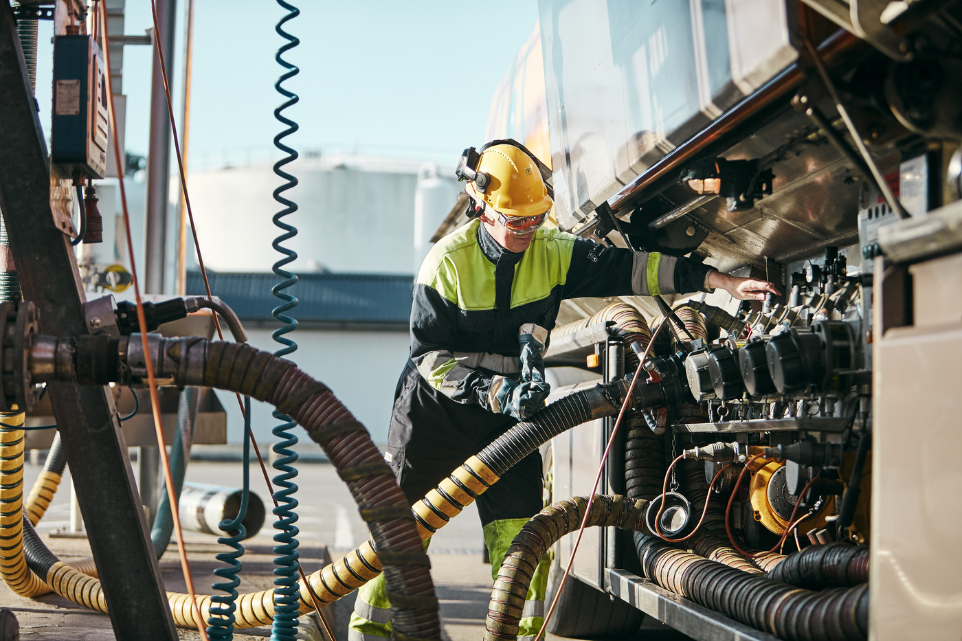 Person fyller på drivmedel på stort fordon