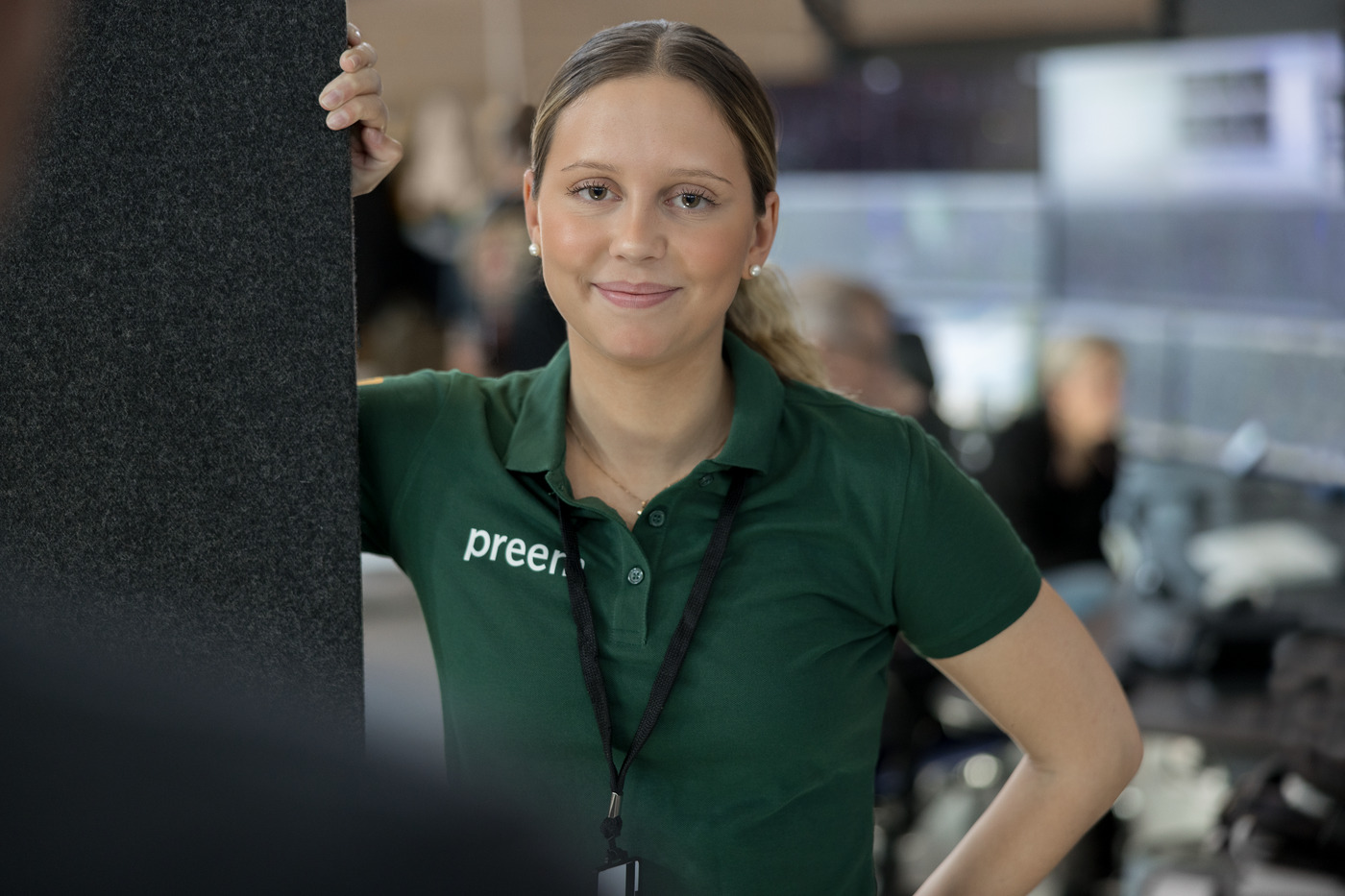 Kvinnlig Preem-anställd i en grön piké med Preem-logga